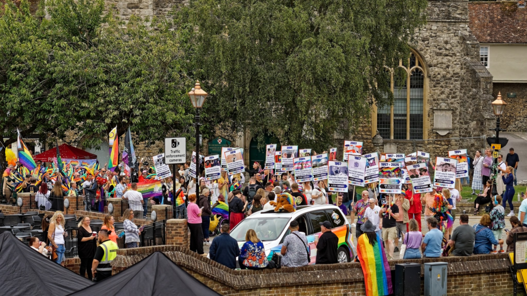 Photo of Medway Prie Parade turning onto Castle Hill Rochester, Image shows  Medway Pride Car followed by procession of 28 placards depicting steps forward and steps backwards for LGBTQIA+ equality Law from 1957 to 2025.
Medway Pride Parade 2025